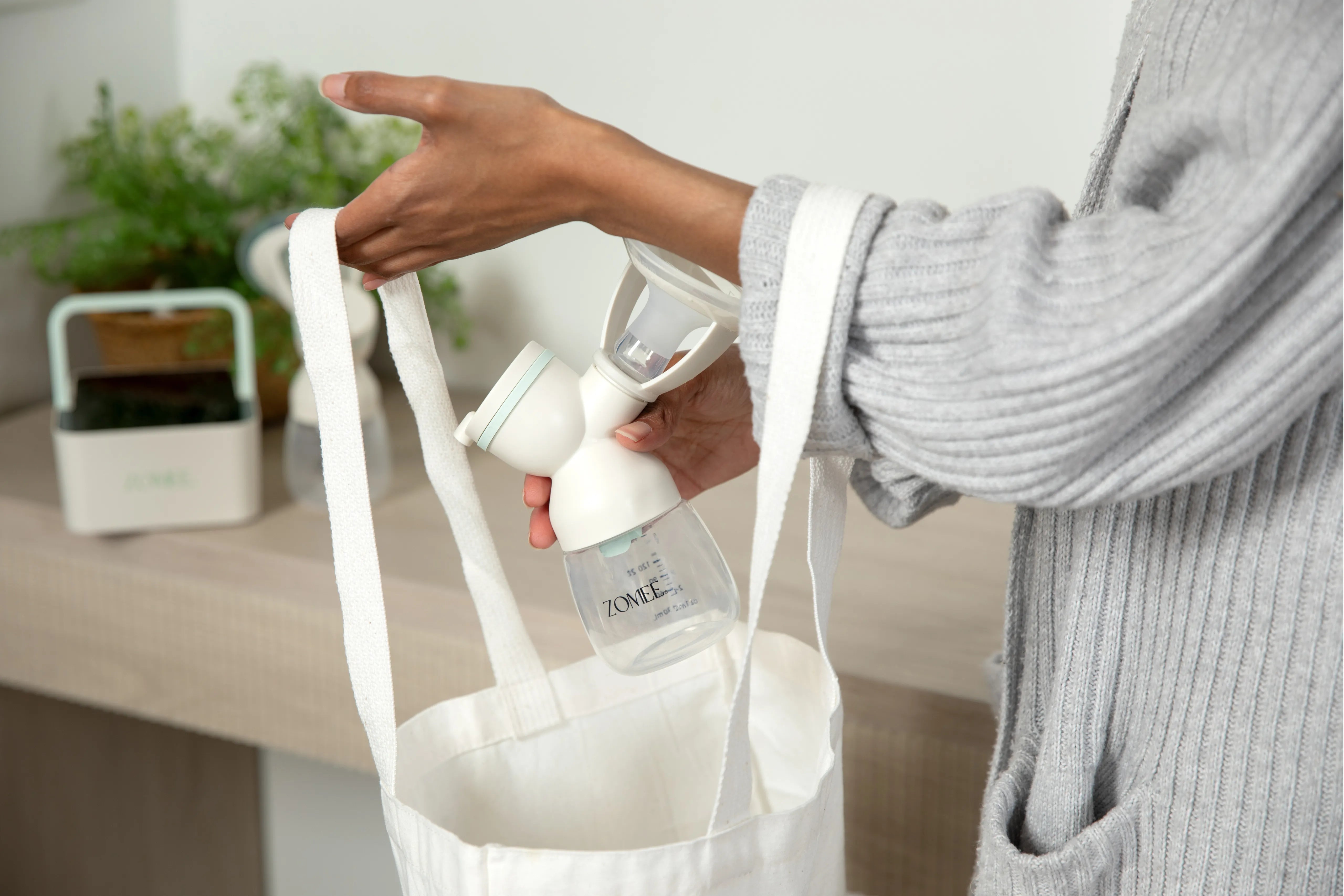 Woman putting the Mother's Nature H1 breast shield into a tote bag