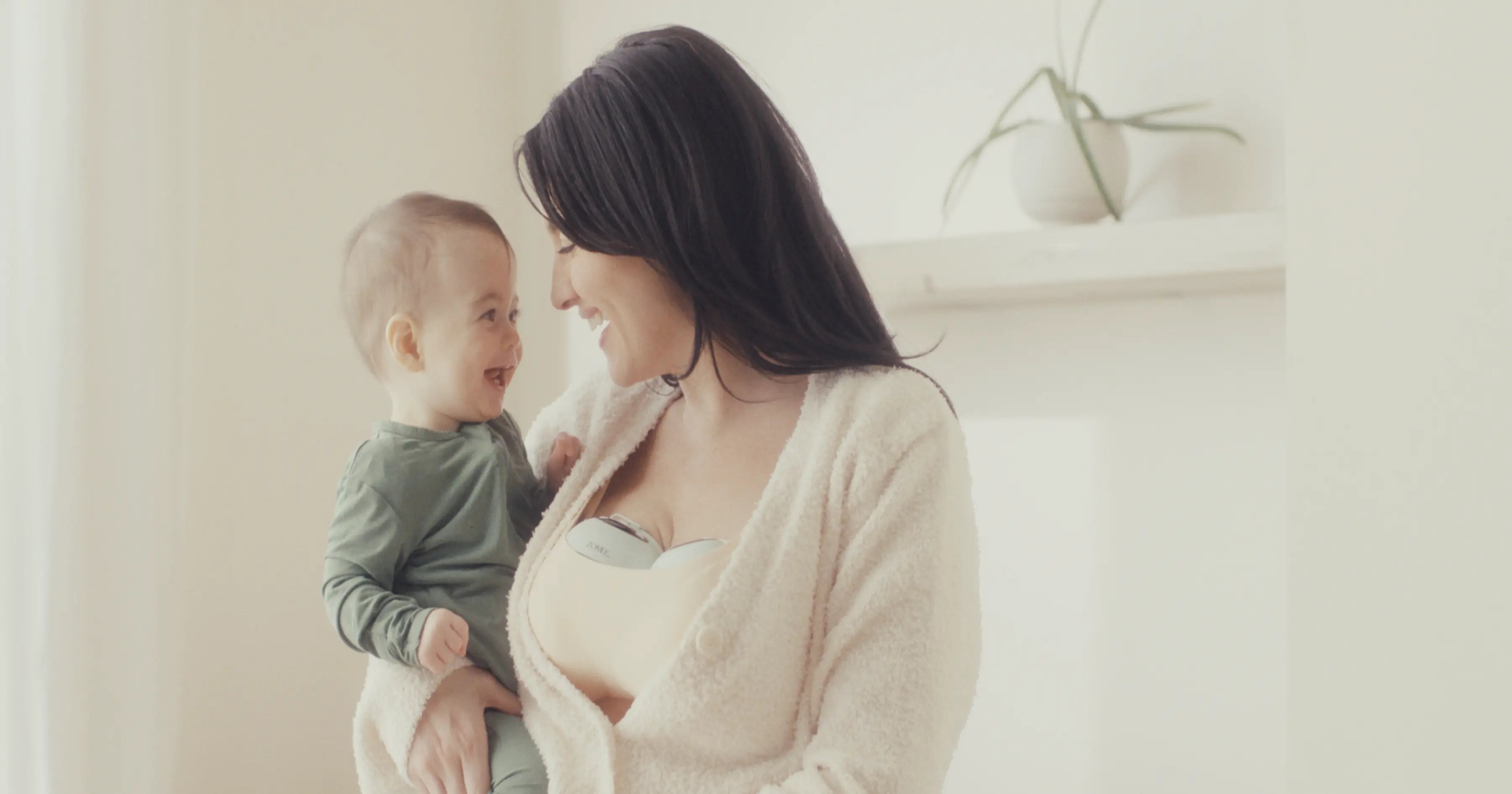 mother having an intimate moment with her baby while wearing the Zomee Mothers Nature™ W1 wearable breast pump