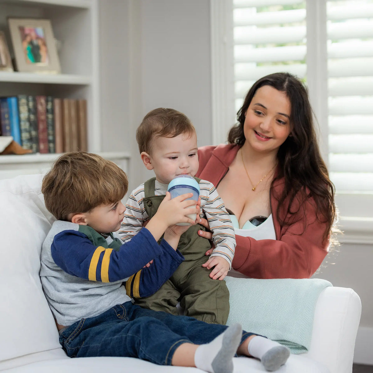 mom wearing breast pumps while sitting with kids