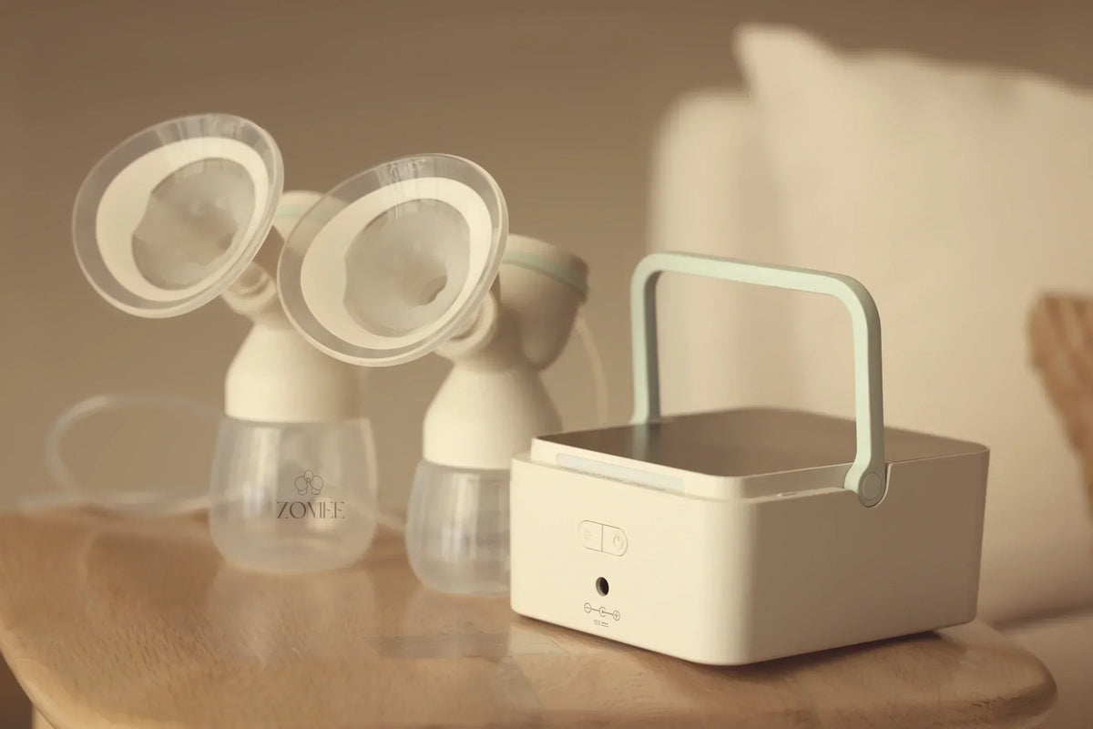 Mom sitting on the couch using the Mother’s Nature™ H1 Hospital Grade, Dual-Motor Breast Pump