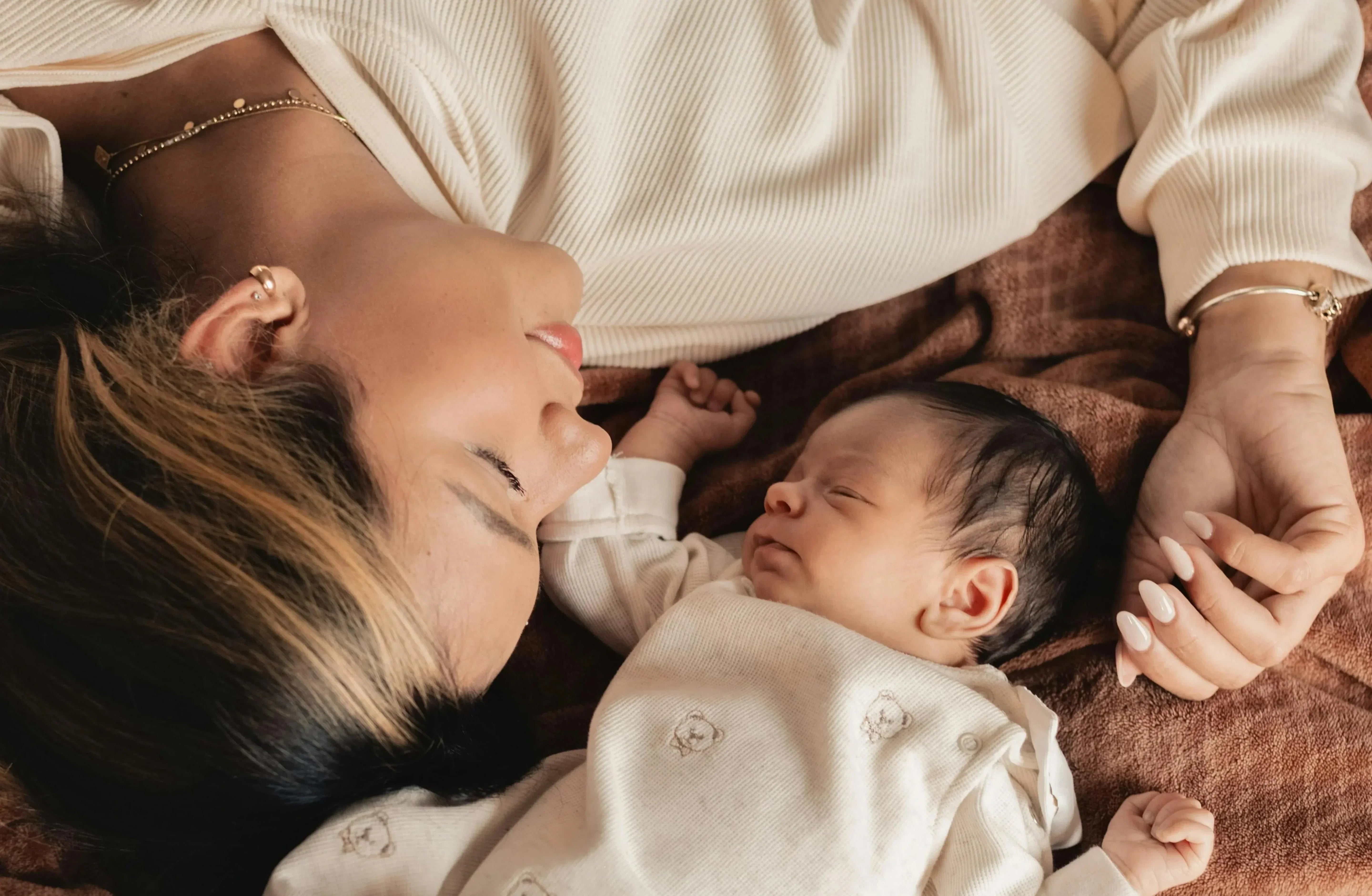 Mom and baby laying down together side by side