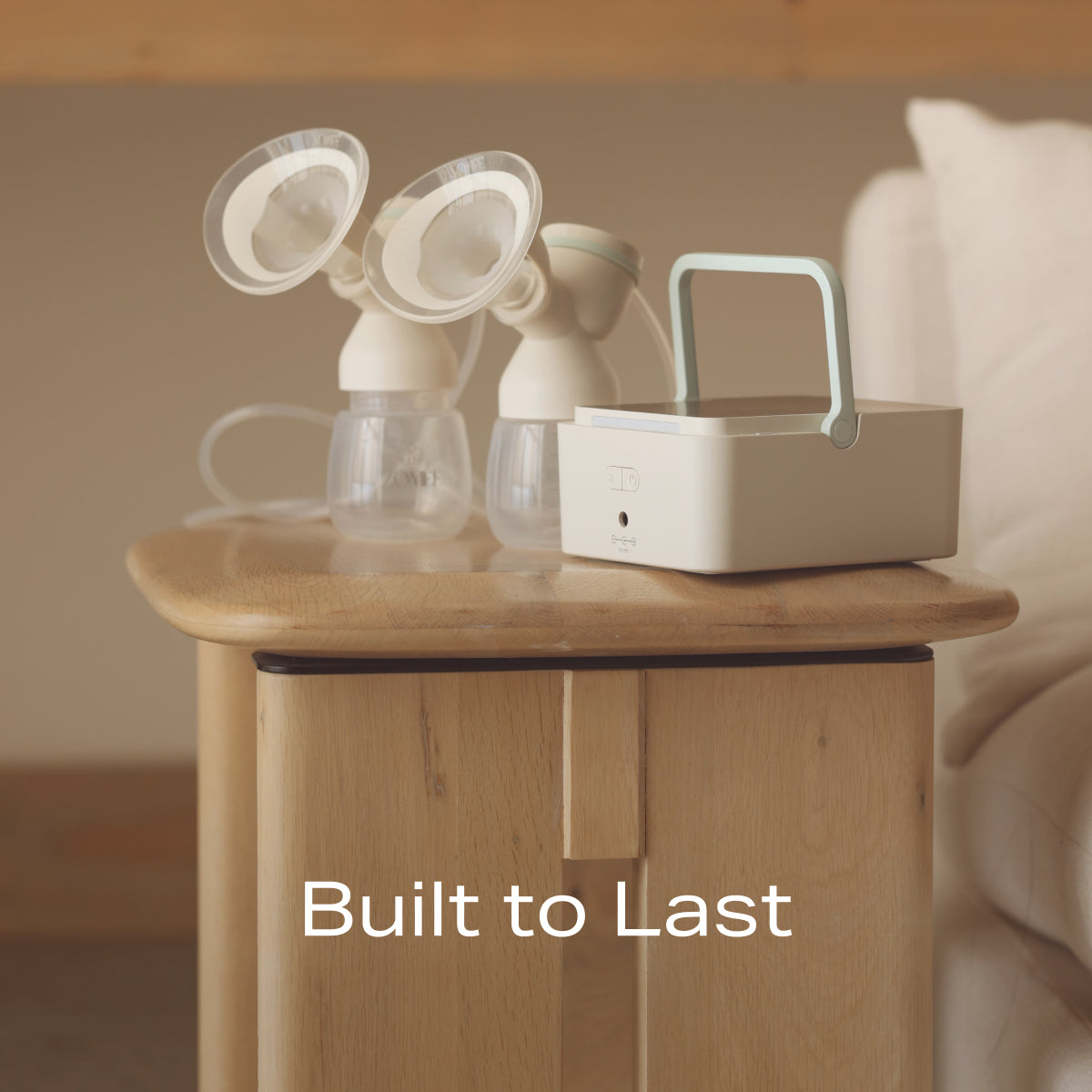 Mother's Nature H1 Breast Pump on a tabletop next to a couch