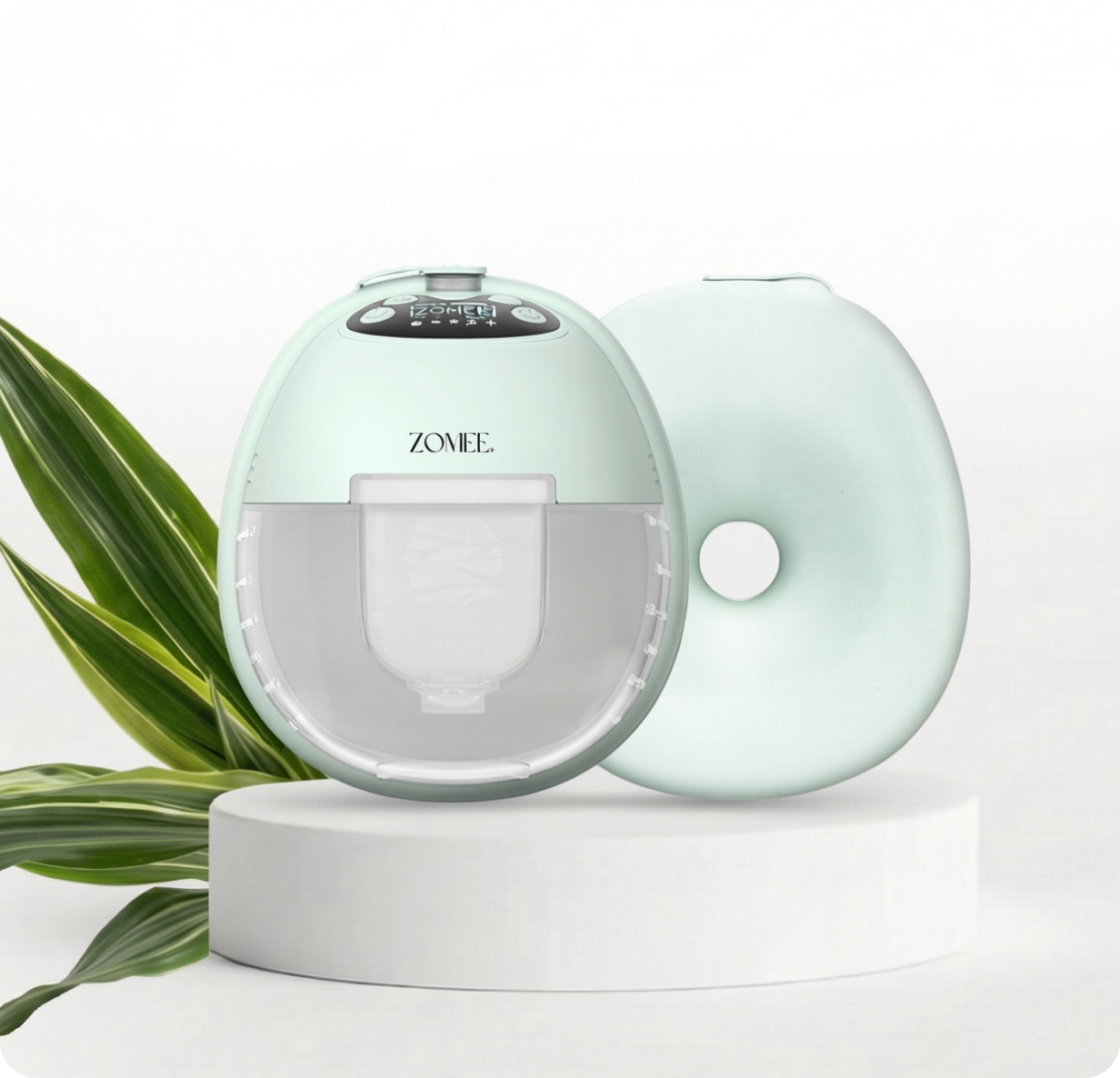 Mother's Nature W1 Breast Pump on a white pedestal and green leaves behind it