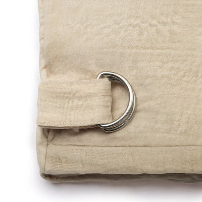 up close view of silver hooks on beige muslin nursing cover