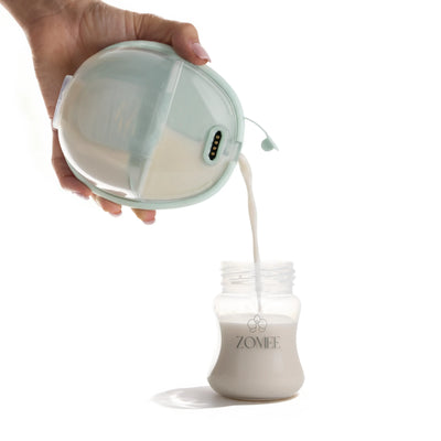 milk being poured out of the mother's nature w1 breast pump into a zomee bottle cup